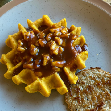 Pumpkin spice waffles topped with a topping made from canned pumpkin, real maple syrup and chopped apples and walnuts.