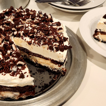 Super Minty Ice Cream Cake with Oreo Crust has vanilla ice cream with mint, fudge, whipped cream and peppermint patties