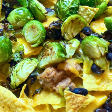 Crispy tortilla chips piled high with cheese, beans, green chiles and roasted brussel sprouts