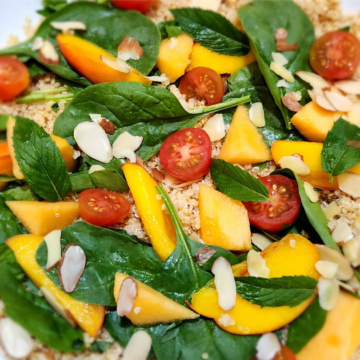 This Summer Fruit Spinach Couscous Salad is loaded with bright colorful peaches, cantaloupe, tomatoes, spinach, veggies, and crunchy couscous topped with slivered almonds, fresh mint, and a sweet honey vinaigrette.