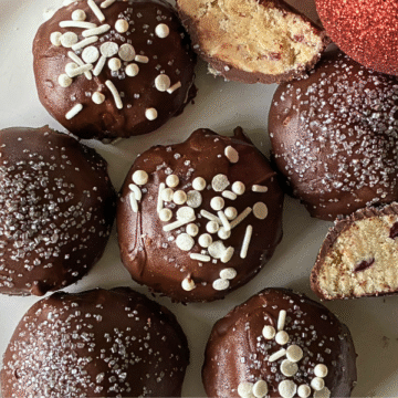 These melt-in-your-mouth Chocolate Covered Cranberry Snowball Cookies are rich and buttery, loaded with finely ground almonds and dried cranberries, then dipped in a thick dark chocolate coating