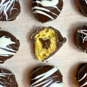 Vanilla cake and buttercream frosting create a creamy, cakey middle that's covered in a milk chocolate coating, with white chocolate drizzle and a surprise Hershey Kiss candy treat inside!