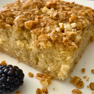 A thick, fluffy layer of maple-flavored pancakes, topped with crunchy granola and chunks of cashews.