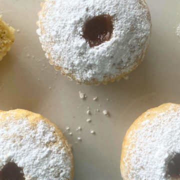 Fluffy vanilla cupcakes filled with strawberry jam and topped with powdered sugar!