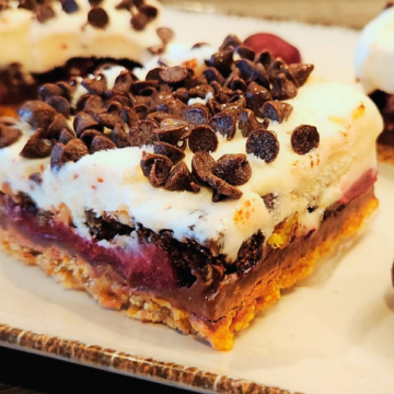 A graham cracker crust, layers of fresh cherry topping, dark chocolate, and vanilla ice cream, and topped with Oreo cookie crumbs and pecans.