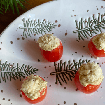 These creamy pesto filled cherry tomatoes are a super simple, festive and delicious holiday appetizer.