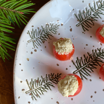 These creamy pesto filled cherry tomatoes are a super simple, festive and delicious holiday appetizer.